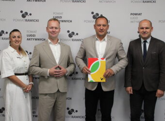 powierzenie obowiązków Dyrektora. 4 osoby a tle baneru z Logo Powiatu rawickiego.